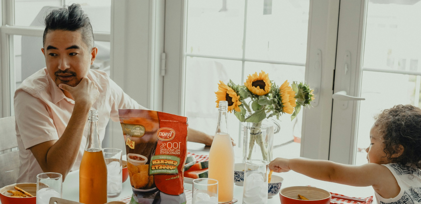 Parent and child eating breakfast at a table