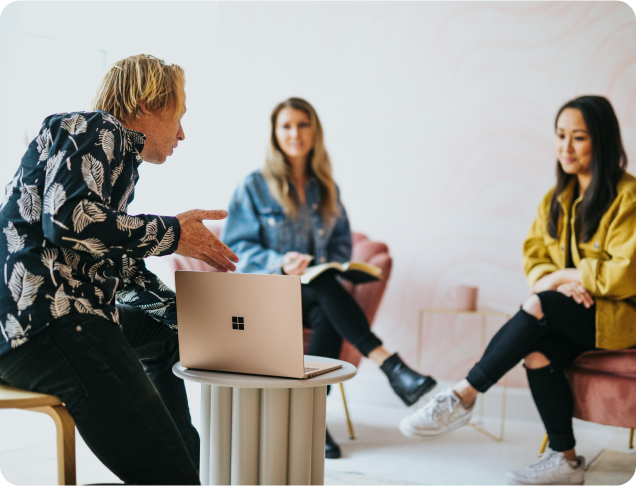 3 people having a conversation around a computer